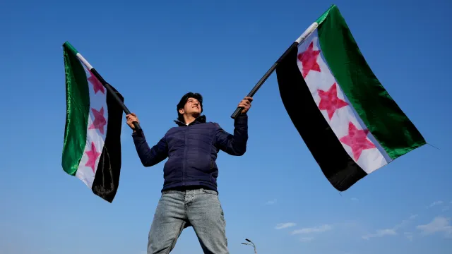 A Syrian man waves the Syrian “revolutionary” flags, as he continues to celebrate the ousting of Bashar al-Assad’s government, at Umayyad Square, in Damascus, Syria, Friday, Dec. 20, 2024. (AP Photo/Hussein Malla)